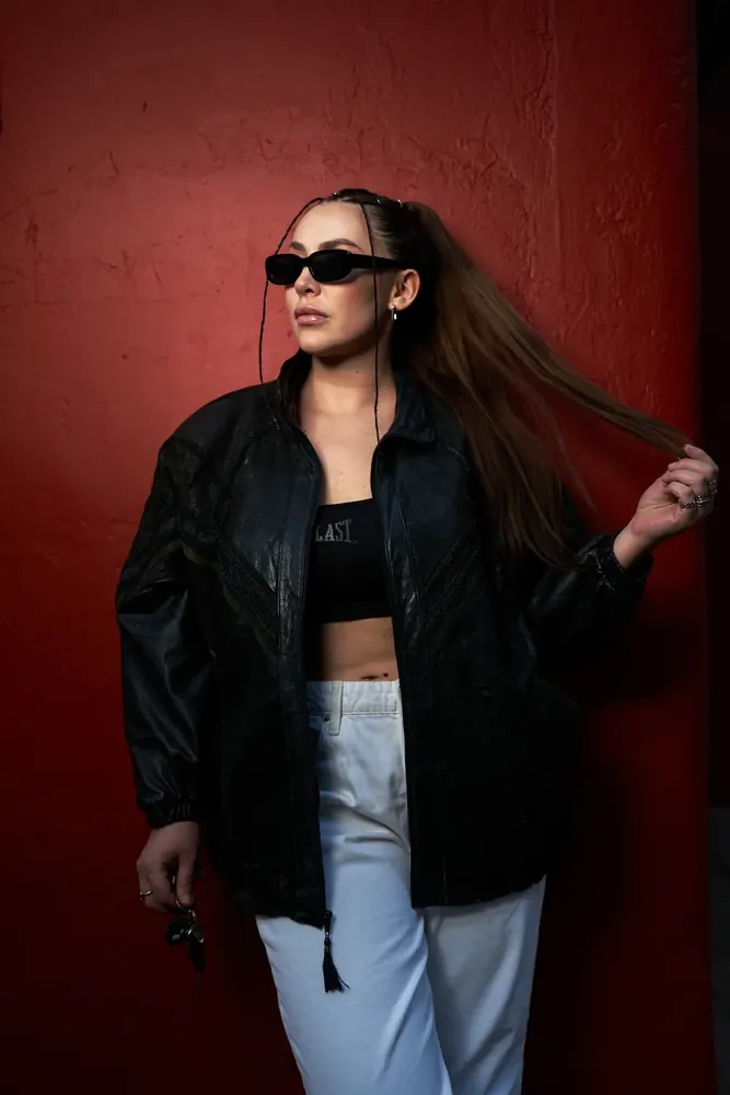 Sesión editorial de moda: chaqueta de cuero sobre muro rojo