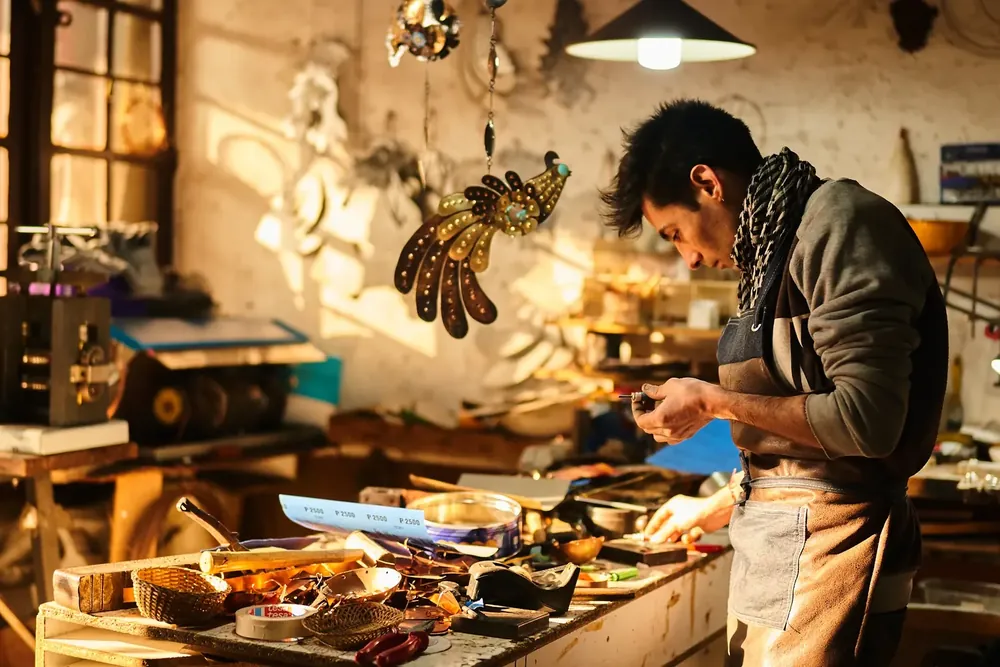 Artesano trabajando en su taller con luz cálida de ventana
