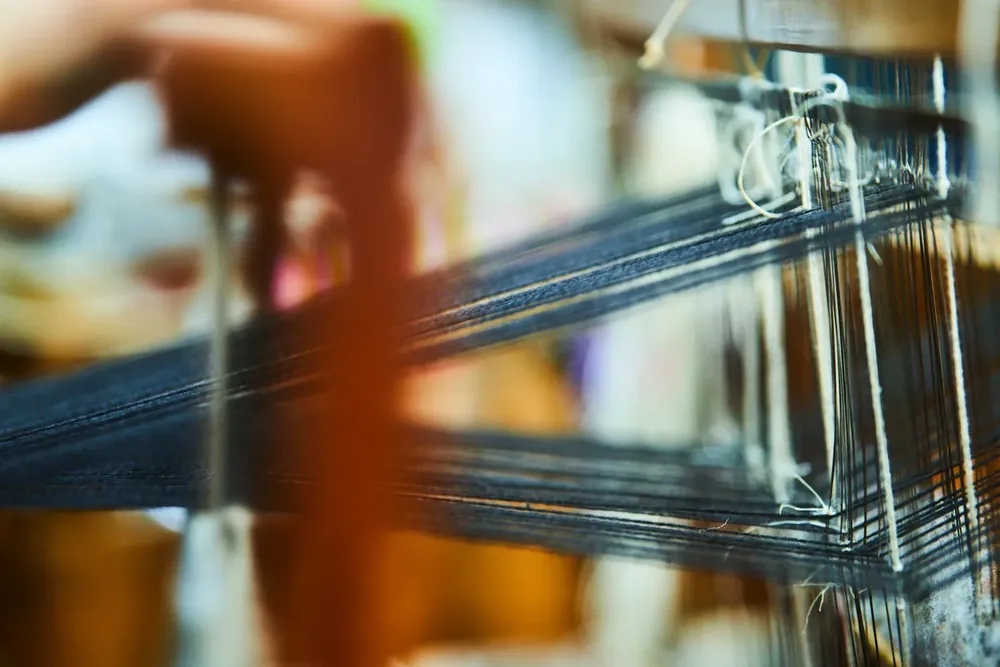 Telar artesanal en funcionamiento, oficio textil