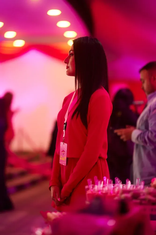 Invitada en evento bajo luces magenta