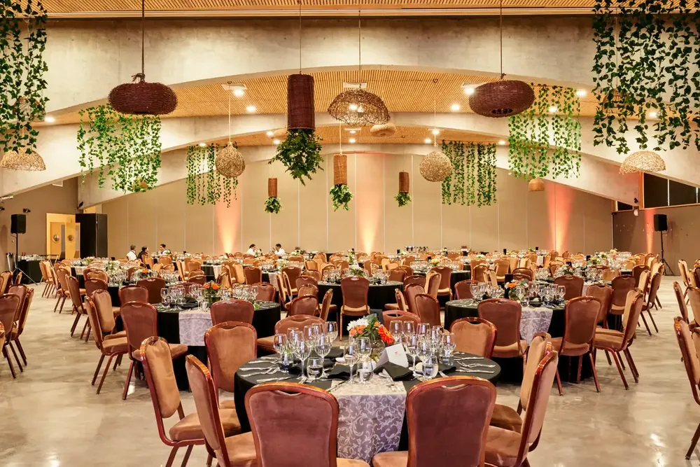 Salón de evento corporativo montado, mesas y ambientación colgante