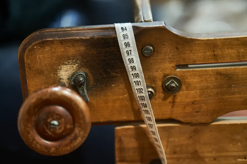 Detalle de un telar de madera con huincha de medir