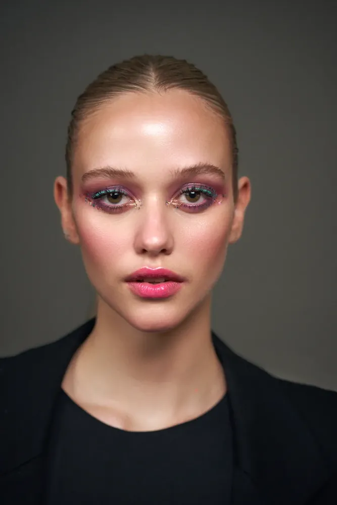 Retrato editorial de maquillaje con brillo, fondo neutro de estudio
