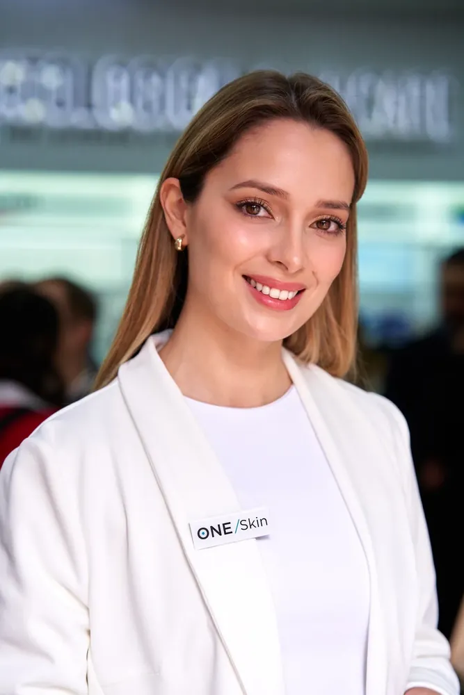 Retrato profesional en evento de marca, sonrisa directa a cámara